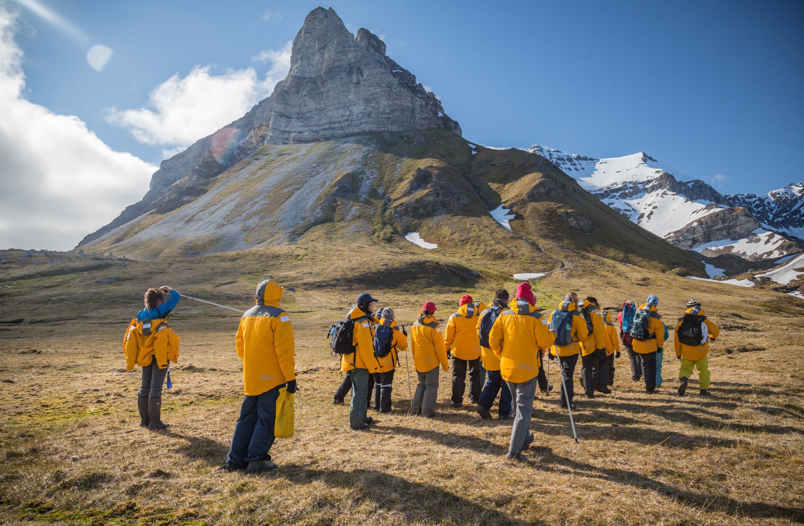 Guests hiking the tundra next to mountain peak in Svalbard.