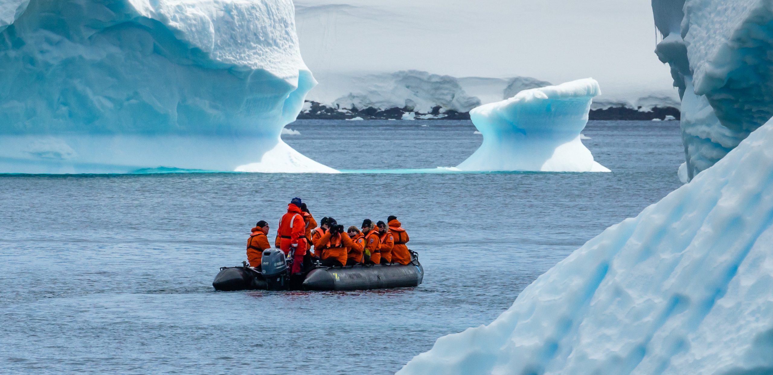 Zodiac cruising in between icebergs.