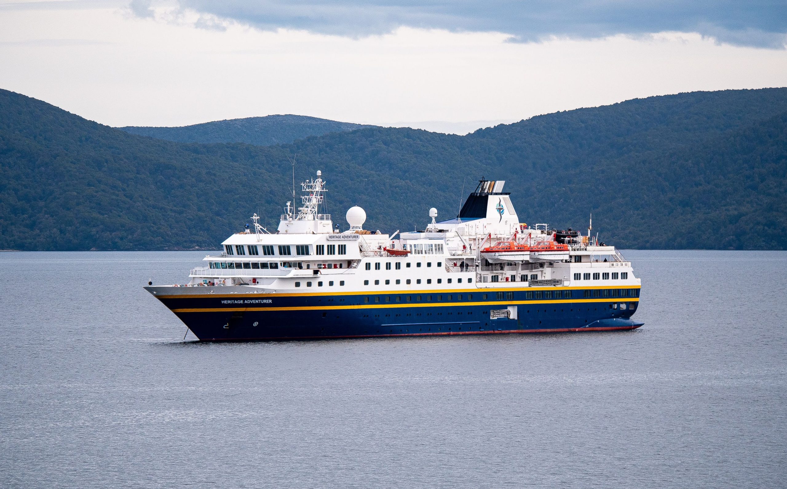 Exterior view of the ship Heritage Adventurer sailing on the water.